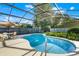 Beautiful pool area with screened enclosure, lush landscaping, and outdoor seating at 11730 Kennington Ct, Orlando, FL 32824