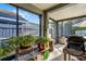 Relaxing screened porch featuring natural light, potted plants, and an outdoor grill at 11730 Kennington Ct, Orlando, FL 32824