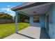 Cozy covered back porch with a view of the green grass lawn and lush foliage at 12303 Bohannon Blvd, Orlando, FL 32824