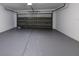 Clean and organized garage with sealed concrete floors and a working garage door in the background at 12303 Bohannon Blvd, Orlando, FL 32824