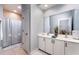 Bright bathroom with a double vanity, framed mirror, walk-in shower, and seashell decor at 1321 Artisan E Ave, Celebration, FL 34747