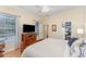 Cozy bedroom features a ceiling fan, a large dresser with TV, and an organized closet at 1321 Artisan E Ave, Celebration, FL 34747