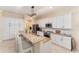 Island kitchen featuring granite countertops, stainless steel appliances, and white cabinets at 1321 Artisan E Ave, Celebration, FL 34747