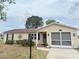 Inviting single-story home with an attached garage, neutral siding, and established landscaping in the front yard at 1410 Sanchez Ct, Lady Lake, FL 32159