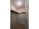 A single light bulb illuminates a walk-in closet featuring white walls and outdated linoleum flooring at 1413 11Th St, St Cloud, FL 34769