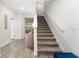 Bright entryway featuring a staircase with carpeted steps and white risers, complemented by wood-look flooring at 14416 Orchid Island Dr, Orlando, FL 32827