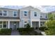 Charming townhouse exterior with light gray siding, complemented by lush landscaping at 14416 Orchid Island Dr, Orlando, FL 32827
