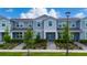 Charming gray townhouse with well-maintained landscaping, lush green grass, and inviting curb appeal at 14416 Orchid Island Dr, Orlando, FL 32827