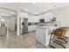 Bright kitchen featuring stainless steel appliances, white cabinetry, quartz countertops, and stylish barstool seating at 14416 Orchid Island Dr, Orlando, FL 32827