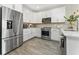 Well-lit kitchen featuring stainless steel appliances, white cabinetry, and sleek countertops, creating a modern culinary space at 14416 Orchid Island Dr, Orlando, FL 32827