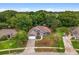 An aerial view of a single-story home with a brick driveway, lush landscaping, and private backyard at 14610 Wishing Wind Way, Clermont, FL 34711