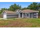 Inviting single-story home featuring a well-manicured lawn, brick driveway, and an attached two-car garage at 14610 Wishing Wind Way, Clermont, FL 34711