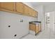 Bright laundry room with overhead cabinets, tile flooring and a utility sink at 14610 Wishing Wind Way, Clermont, FL 34711