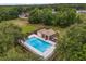 Aerial view of the community pool surrounded by lush greenery and a neighboring grassy field at 14610 Wishing Wind Way, Clermont, FL 34711