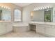 Bathroom featuring dual sinks, soaking tub, and natural light at 1746 Golfview Dr, Kissimmee, FL 34746