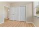 Bedroom features wood flooring, closet, doorway, and a bright window with a view at 1746 Golfview Dr, Kissimmee, FL 34746