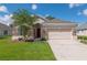 Charming single-story home with a stone facade, well-maintained lawn, and a two-car garage on a sunny day at 1746 Golfview Dr, Kissimmee, FL 34746