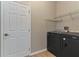 Functional laundry room features modern washer/dryer, metal shelving, and a bright white door at 1746 Golfview Dr, Kissimmee, FL 34746