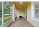 View of the screened-in patio with tiled floor leading to an open door at 1746 Golfview Dr, Kissimmee, FL 34746