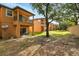 The home has a well-maintained backyard with outdoor seating and mature trees for shade at 203 La Mirage St, Davenport, FL 33897