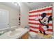 This bathroom offers a Mickey Mouse shower curtain and good lighting at 203 La Mirage St, Davenport, FL 33897