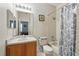 Bathroom with wood-look vanity and shower-tub combo with patterned curtain at 203 La Mirage St, Davenport, FL 33897