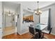 Dining room with a glass-top table and chairs, open to the kitchen area, with hardwood flooring at 203 La Mirage St, Davenport, FL 33897