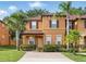 Inviting two-story townhome with neutral stucco exterior, manicured landscaping, and brick-paved driveway at 203 La Mirage St, Davenport, FL 33897