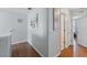 Upstairs hallway with wood floors, artwork, and access to multiple rooms at 203 La Mirage St, Davenport, FL 33897
