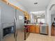 Well-lit kitchen featuring stainless steel appliances, tile flooring, and a view into the adjacent room at 203 La Mirage St, Davenport, FL 33897