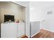 Bright laundry area featuring a white washer and dryer next to the staircase and wood floors at 203 La Mirage St, Davenport, FL 33897