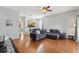 Spacious living room featuring hardwood floors, a sectional sofa, and views into the kitchen and dining area at 203 La Mirage St, Davenport, FL 33897