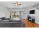 Open living room with hardwood floors, a comfortable sofa, and access to an outdoor patio at 203 La Mirage St, Davenport, FL 33897