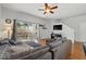 Cozy living room with a sectional couch, patio access, hardwood flooring, and a ceiling fan at 203 La Mirage St, Davenport, FL 33897
