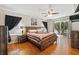 Bright main bedroom features a ceiling fan, wood floors, and sliding glass door leading to a balcony at 203 La Mirage St, Davenport, FL 33897