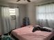 Bedroom with light walls, two windows, air conditioner, and an open metal shelf at 2329 W Doris St, Kissimmee, FL 34741