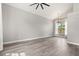 Bright living room with vaulted ceiling, ceiling fan, wood-look flooring, and a large window at 2421 Deermeadow Dr, Apopka, FL 32703