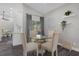 Cozy dining area with a glass table, four chairs, and view of kitchen with checkered curtains at 248 Country Landing Blvd, Apopka, FL 32703
