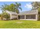 Back exterior view of home featuring screened patio, mature trees and a well-manicured lawn at 248 Country Landing Blvd, Apopka, FL 32703