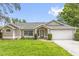 Charming single-story home featuring a well-manicured lawn, attached two car garage, and a decorative front door at 248 Country Landing Blvd, Apopka, FL 32703