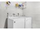 Bright laundry room with white washer and dryer, shelving above, and white tile walls at 248 Country Landing Blvd, Apopka, FL 32703