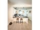 Modern kitchen with a breakfast bar, pendant lighting, white cabinets, and neutral tile flooring at 2547 Trielle Ave, Kissimmee, FL 34741