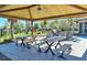 Covered outdoor kitchen with grill, bar seating, and picnic tables perfect for entertaining at 2547 Trielle Ave, Kissimmee, FL 34741