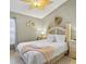 Cozy bedroom with a queen bed, light wood furniture, and a unique leaf-shaped ceiling fan at 2567 Oneida Loop, Kissimmee, FL 34747