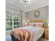 Bright bedroom with a large window, natural lighting, and a cozy queen bed at 2567 Oneida Loop, Kissimmee, FL 34747