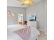 Bright bedroom with stylish ceiling fan, a dresser with television, and a light pink blanket accent at 2567 Oneida Loop, Kissimmee, FL 34747