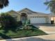 Inviting single-story home with a well-maintained front yard, manicured bushes, and an attached two car garage at 2567 Oneida Loop, Kissimmee, FL 34747