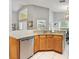 Bright eat-in kitchen featuring granite countertops, stainless steel dishwasher, and light wood cabinets at 2567 Oneida Loop, Kissimmee, FL 34747