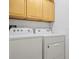 Functional laundry room with a side-by-side washer and dryer and extra storage space above at 2567 Oneida Loop, Kissimmee, FL 34747