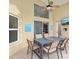Relaxing outdoor patio with a dining table, ceiling fan, and wall-mounted TV for entertainment at 2567 Oneida Loop, Kissimmee, FL 34747